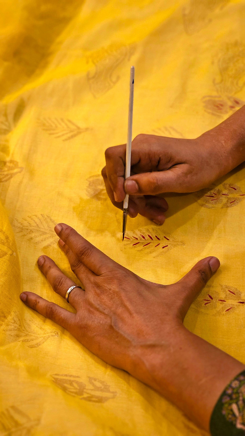 Hand block printing on yellow cloth.