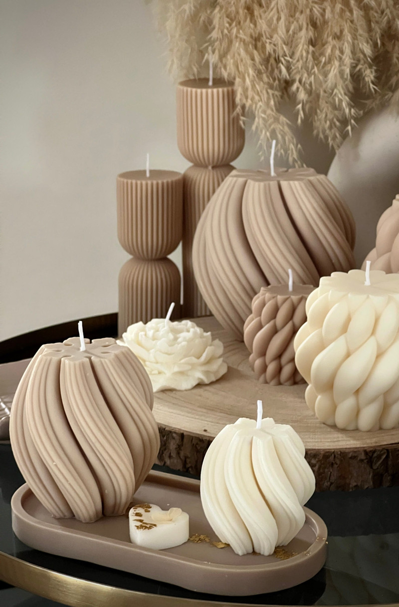 Sculpted swirl candles in sand and cream.