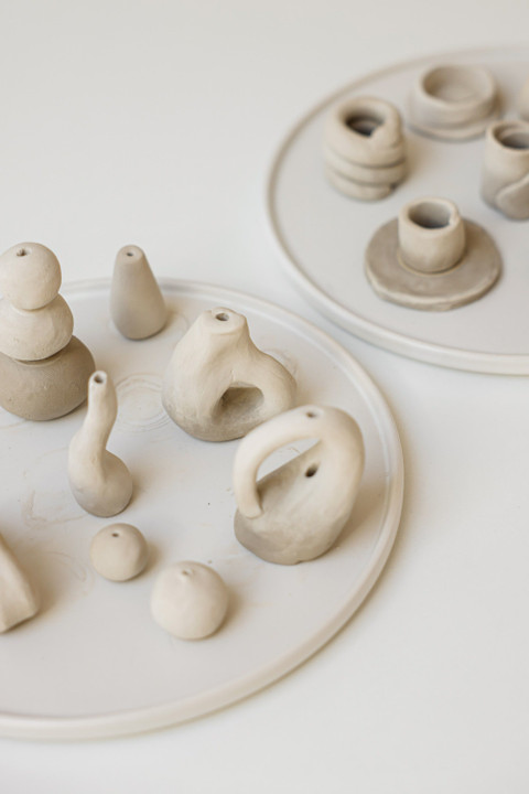 Clay trinkets gathered on a round platter.