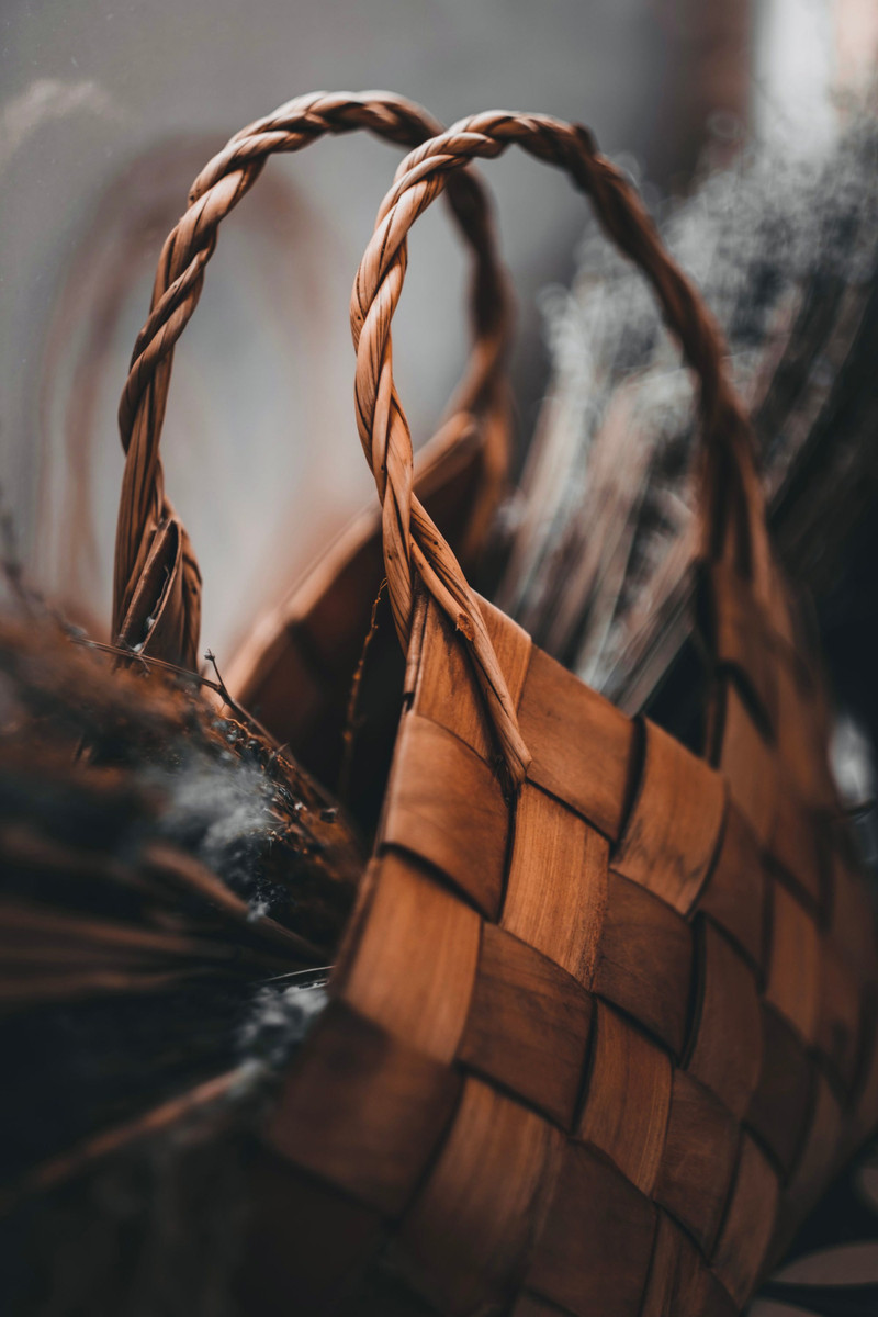 A woven leather market basket with braided handles.