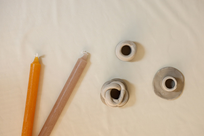 Ochre tapers beside clay holders.