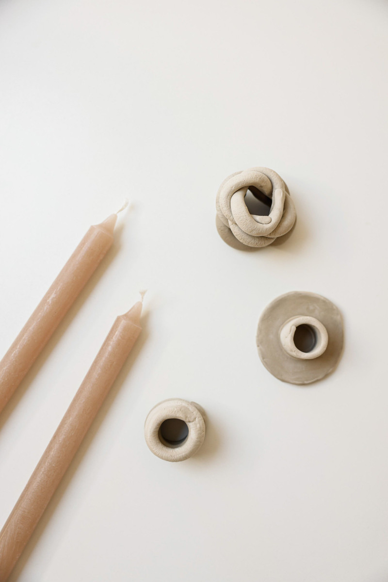 Blush tapers and clay holders on cream.