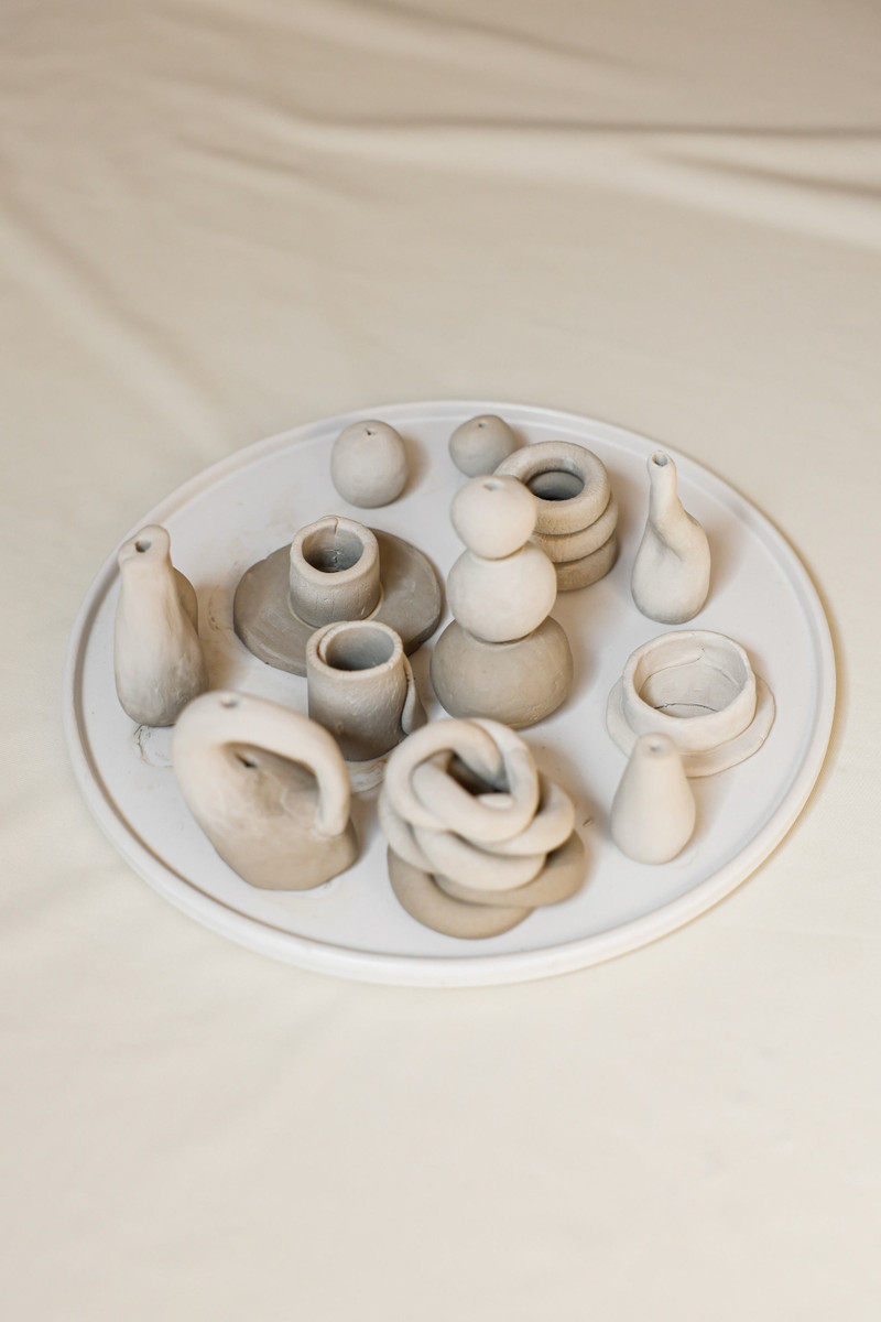 Clay incense holders and a bud vase, close.