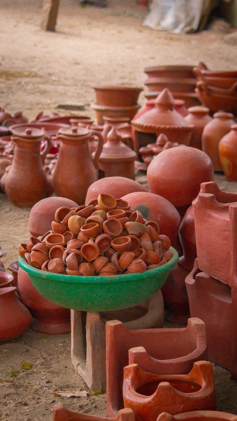 Handmade terracotta pots and planters at a market.