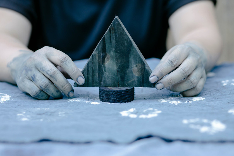 Hands pressing a wooden block onto cloth.